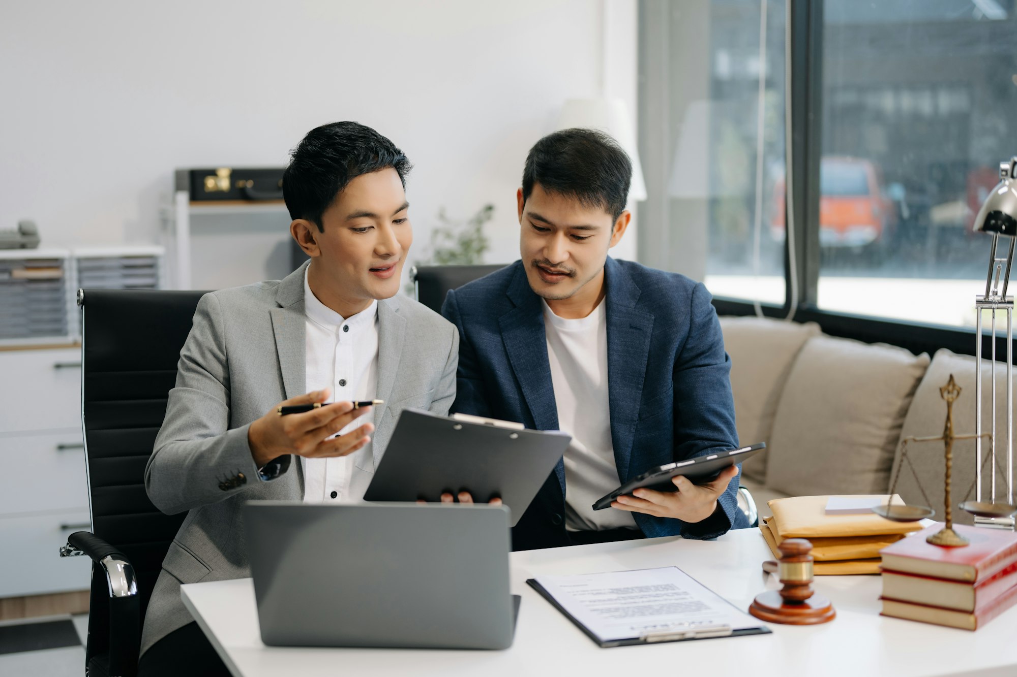 Asian business team and lawyers discussing contract papers sitting at the table.